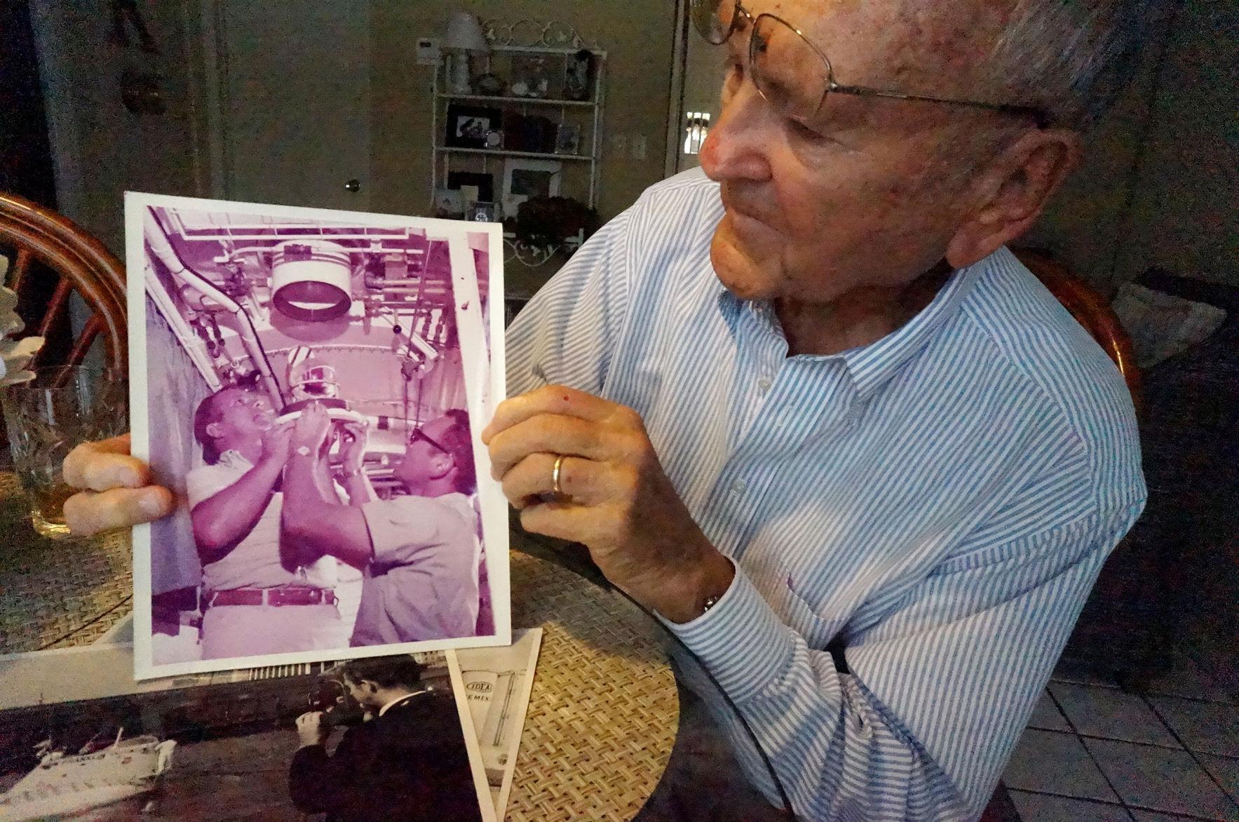 Don Kazimir holds photo showing him and another crew member of the Ben Franklin